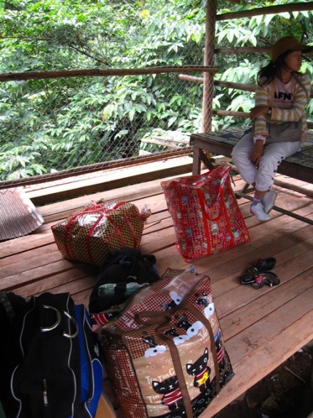 A Shan girl with her belongings, waiting at the border crossing. 