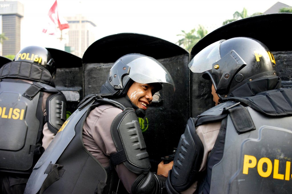 Police chat while holding off Prabowo's supporters.