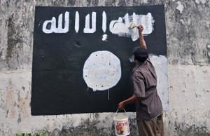 A city worker paints over an IS flag on a wall in Surakarta, Indonesia. Photo by AAP.