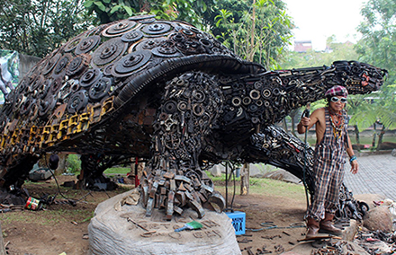 Metal sculptor Ono Gaf with his turtle in Batu, East Java. Photo by Duncan Graham. 