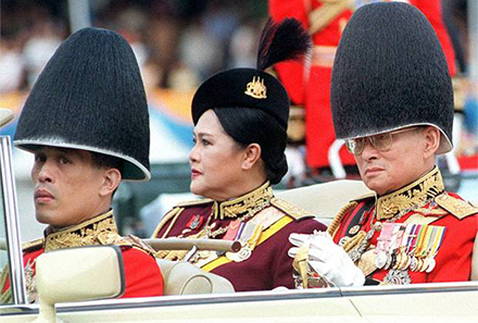King Bhumibol Adulyadej, Queen Sirikit and Crown Prince Maha Vajiralongkorn review troops in Bangkok. Photo by AFP.