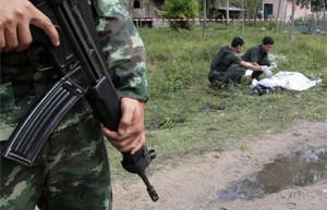 Soldiers inspect the body of a suspected insurgent after a clash with Marines at a navy base in Narathiwat province, southern Thailand. Photo: The Nation.