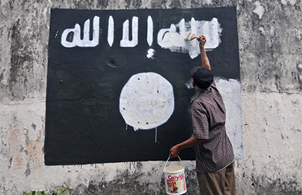 INDONESIA, Surakarta City: A government worker removes ISIS (Islamic State of Iraq and Syria) flags painted on to walls near Veteran Street in Surakarta City in an attempt to discourage the promotion of the jihadist group in the region. (AAP Image/NEWZULU/AGOES RUDIANTO). NO ARCHIVING, CROWD SOURCED CONTENT, EDITORIAL USE ONLY