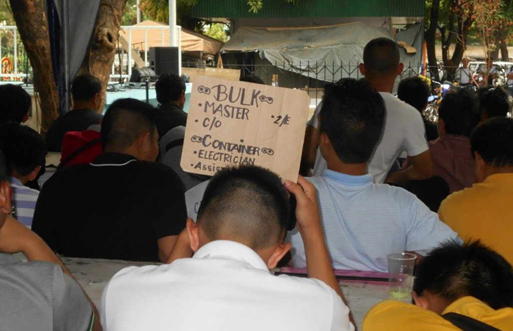 A utility man recruiting seafarers at Manila’s informal seamen’s market along Kalaw Street.