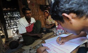A Muslim man (left) answers questions during a census taking in the village of Barasa. Photo by AFP.