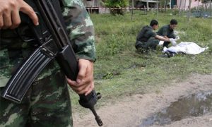 Soldiers inspect the body of a suspected insurgent after a clash with Marines at a navy base in Narathiwat province, southern Thailand. Photo: The Nation.